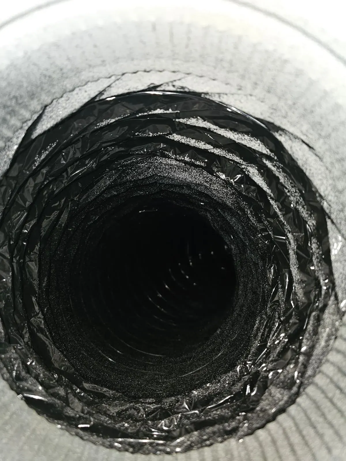 After: the same flexible duct with a clean black liner and shiny foil