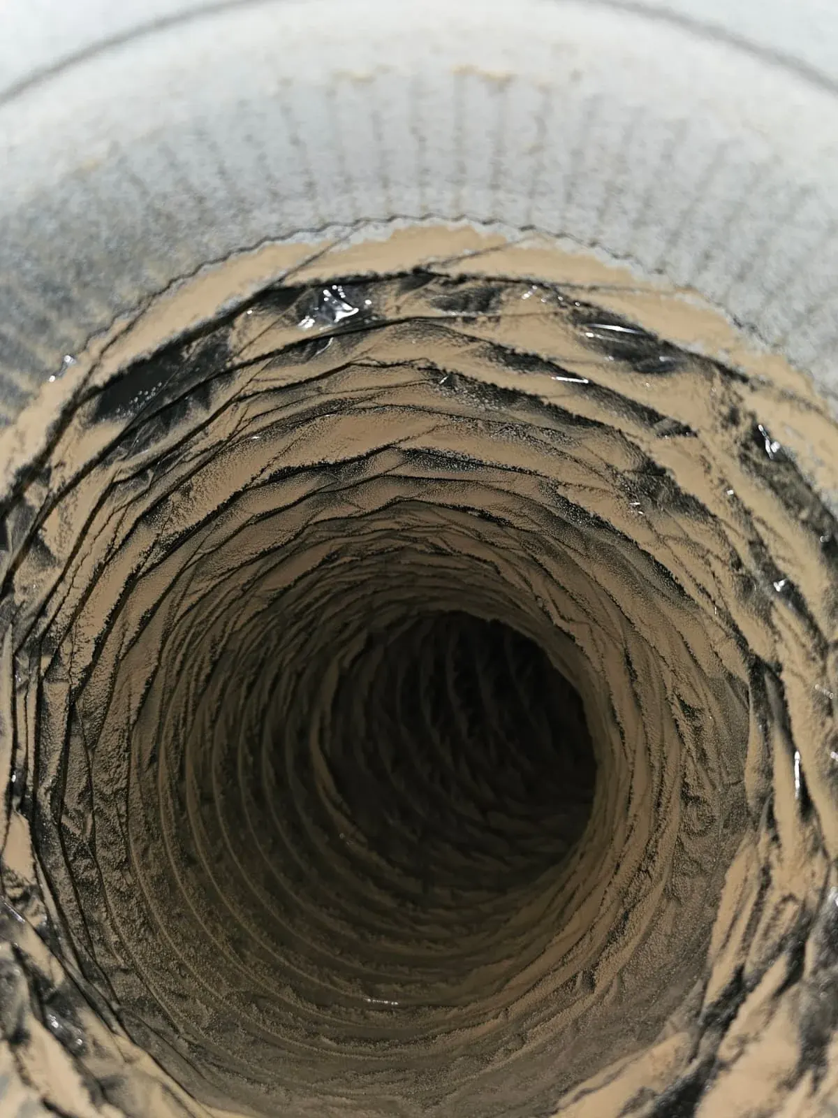 Before: flexible duct coated in tan dust
