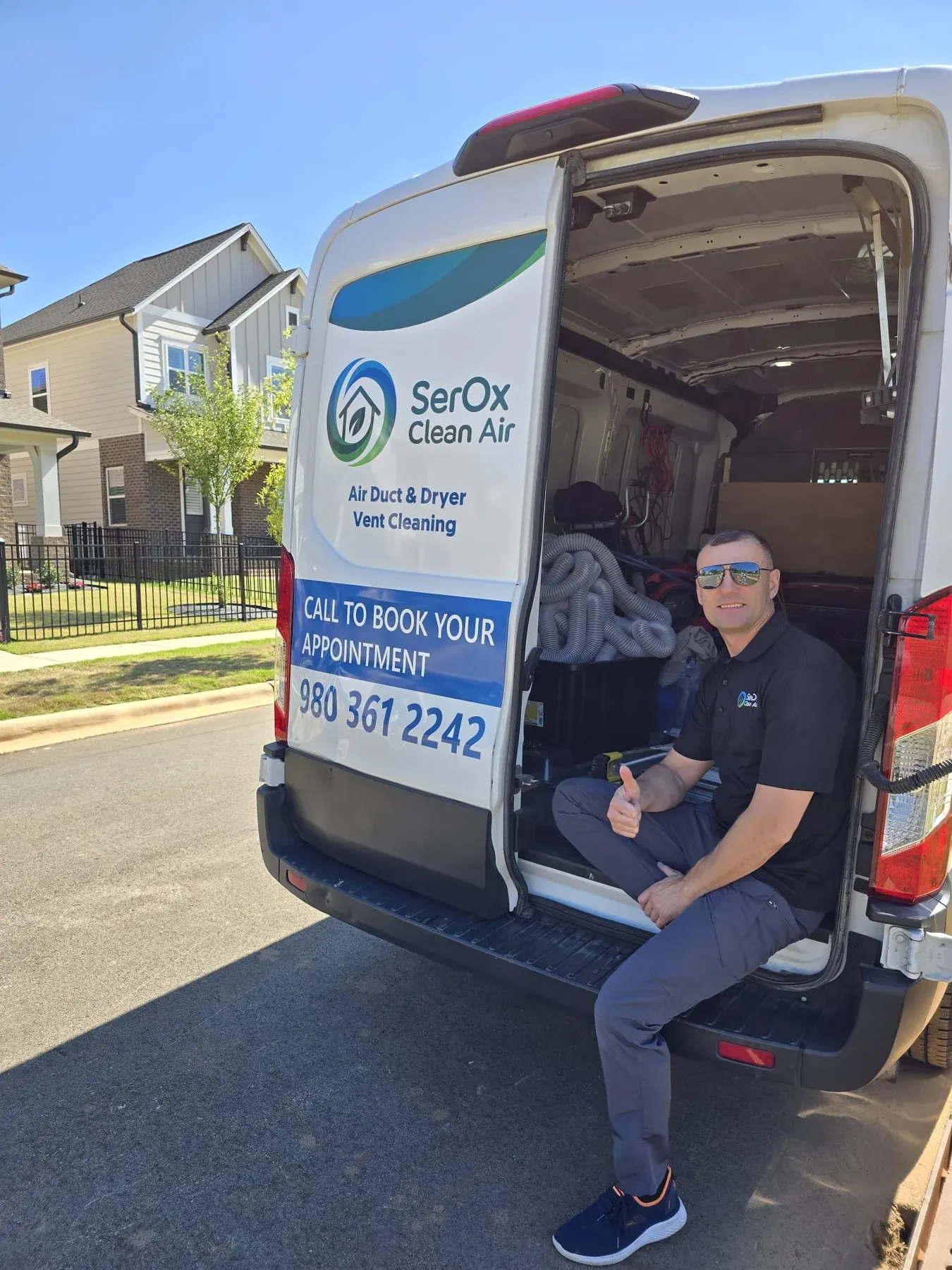 Serhii giving a thumbs up while seated at the rear of the branded SerOx van