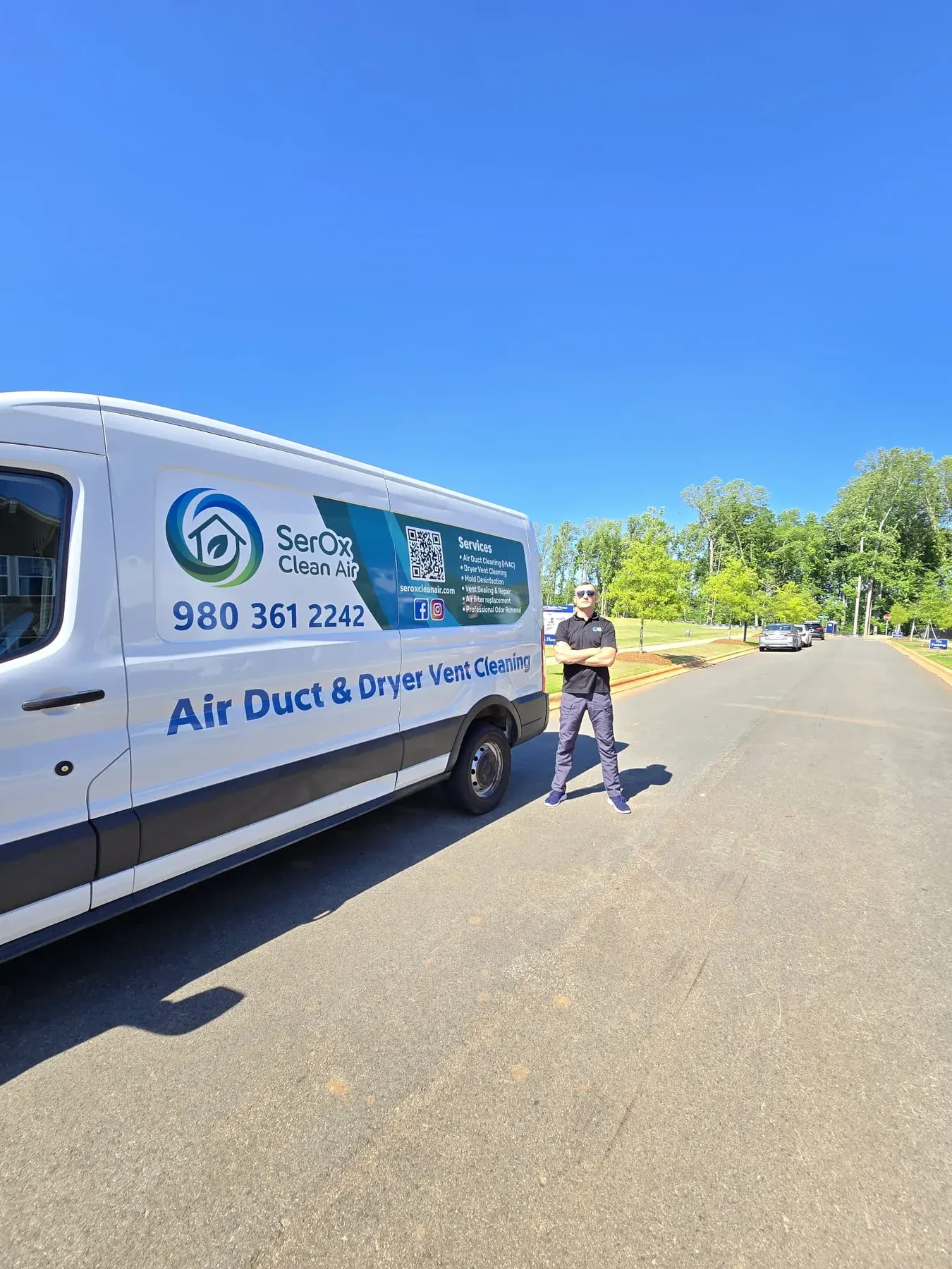 Branded SerOx van parked on a residential street with Serhii standing beside it